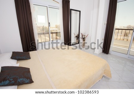 Double bedroom in an apartment with two large windows