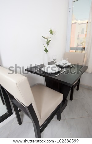Small dining table for two in a luxury apartment by window