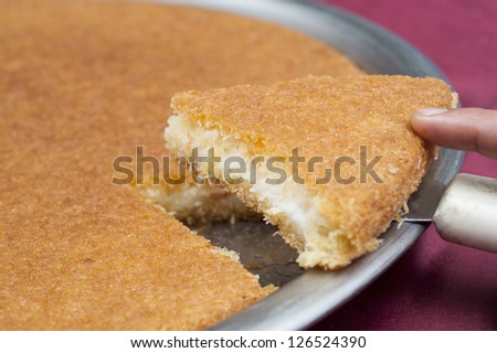 Oriental basbousa cake on a plate with slice being served