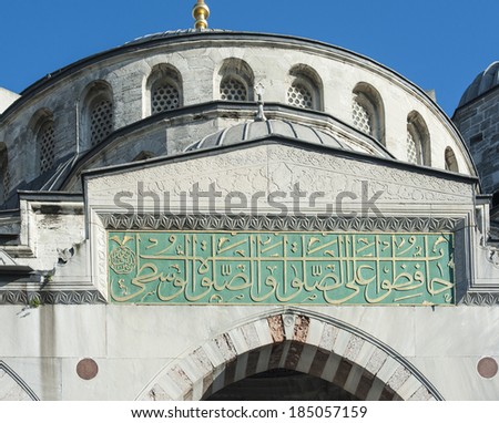 Old arabic calligraphy writing over the entrance to a large mosque