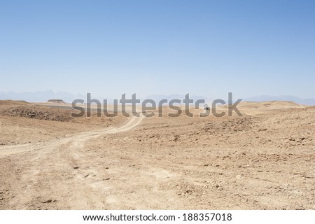 Desert safari in an off road vehicle across an empty arid desert landscape