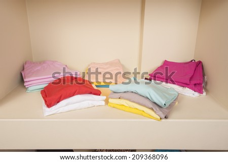 Various selection of womens basic clothes on shelf in fashion shop