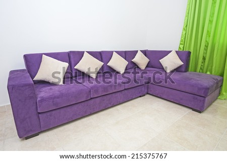 Closeup of purple sofa interior design in living room of luxury apartment