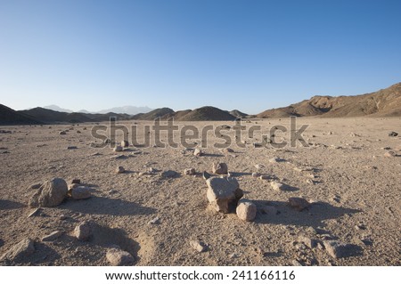 Closeup detail of stony desolate arid desert landscape with mountains