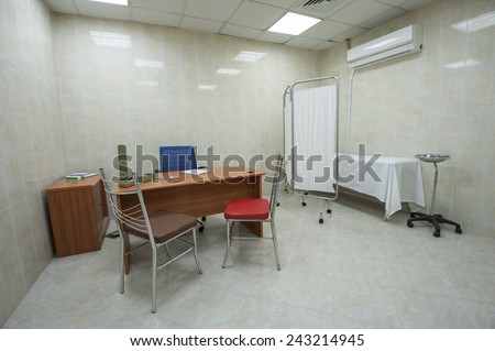 Doctors consultation room with desk and bed in medical center hospital