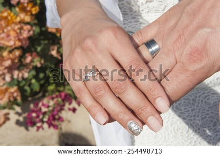 Man and woman hands together from newly married couple showing wedding rings