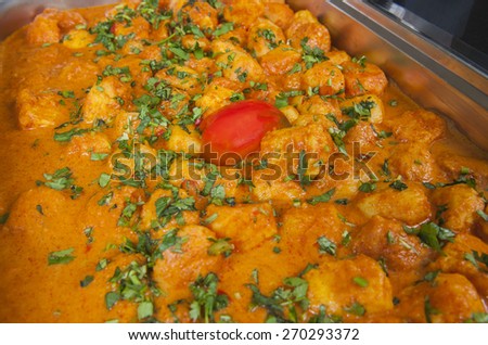 Closeup detail of a dum aloo punjabi potato curry dish on display at an indian restaurant