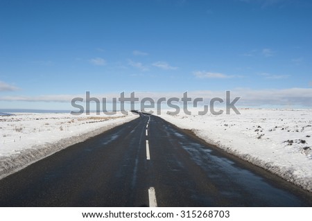 Country road going into distance through english rural winter scene