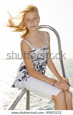 Pretty young girl posing on bow of a boat
