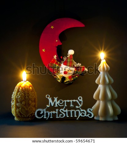 Christmas decoration and merry christmas sign illuminated by christmas candles