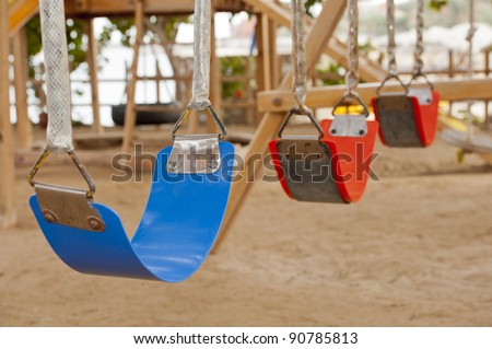Closeup of colorful plastic swings in a childrens play area at park
