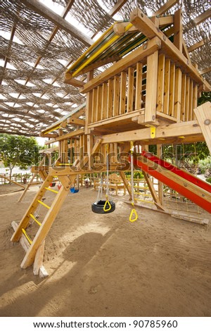 Childrens wooden climbing frame with slide in a playground at park