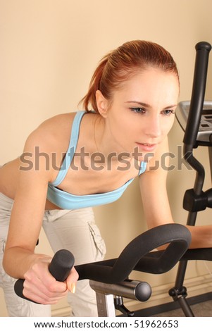 The young woman goes in for sports on training apparatus