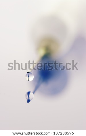 Extreme close-up of syringe with drop. Selective focus on needle point.