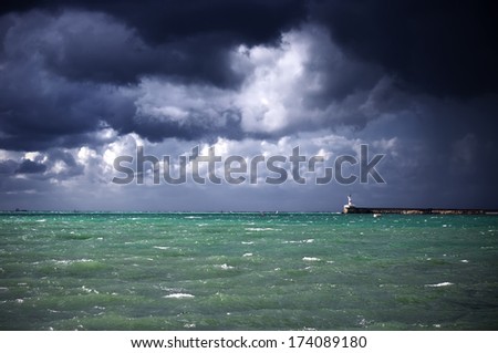 Dark stormy clouds and lighted sea.