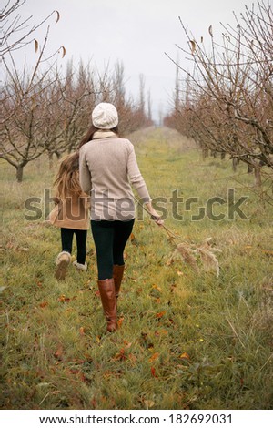 Young mother with her little daughter walking in countryside.