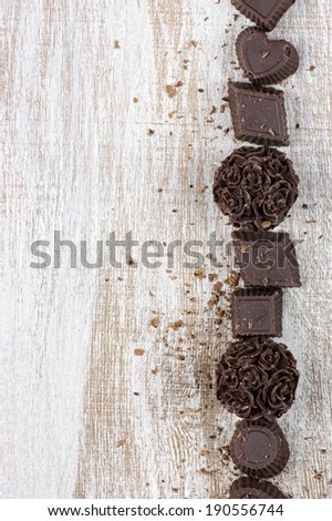 Homemade natural chocolate candies on rustic wooden background.