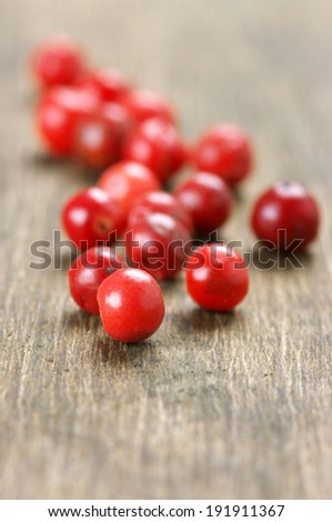 Close-up of pink peppercorns on wooden background.