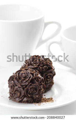 Homemade natural chocolate candies and cups on white background.