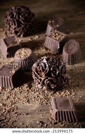 Homemade natural chocolate candies with chips on wooden background.