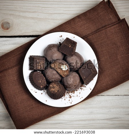 Homemade natural chocolate candy in plate on wooden background.