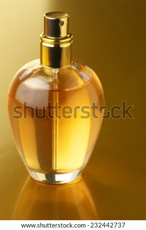 Bottle of woman perfume on gold background.