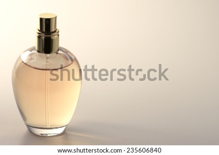 Bottle of woman perfume on light background with copy space. Toned image.