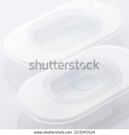 Two new soft contact lenses in individual package close-up. Shallow DOF, focus on front lens.