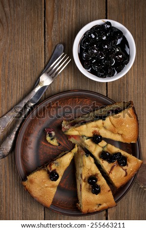 Slices of fruit pie with berries in brown plate on wooden table. Top view point.