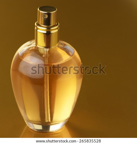 Bottle of woman perfume on gold background.