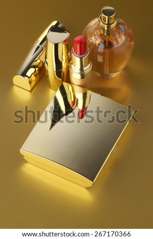 Cosmetic set. Gold powder, lipsticks and perfume on golden background.