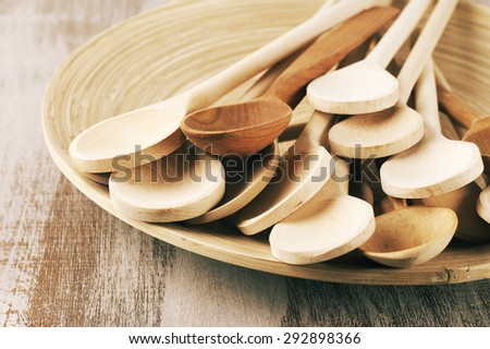 Assorted wood spoons in wooden dish on rustic background. Toned image.