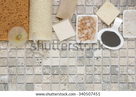 Set of bathroom accessory on stone tile: soaps, bath salt, clay, sponges, loofa. Top view point.