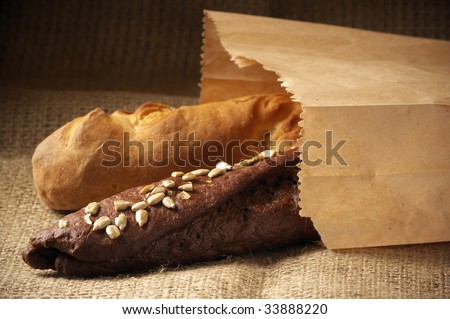 Rye and wheat bread in paper bag on sack.
