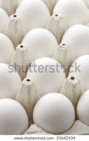 Collection of white chicken eggs in carton box.