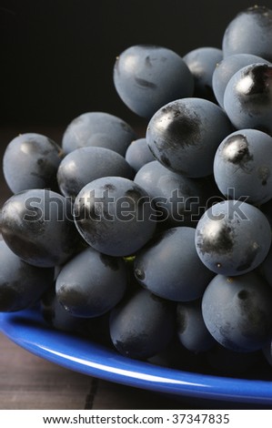 Bunch of fresh ripe dark grape with patina and dust close-up.