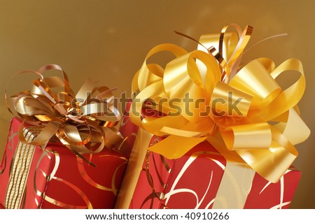 Two red and gold gifts on gold background.