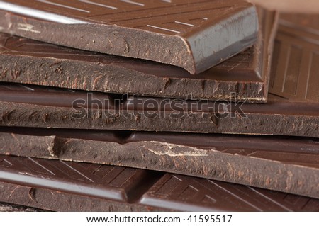 Stack of broken dark chocolate bar close-up. Full frame.