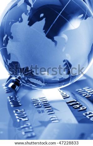 Close-up of glass globe on credit cards. Toned monochrome image. Shallow DOF.