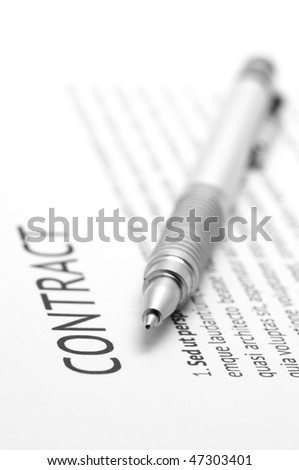 Close-up of silver pen on contract. Selective focus on top of pen.