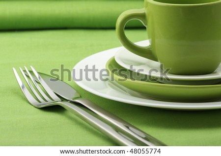 stock photo Green and white plates and cup stainless fork and knife on