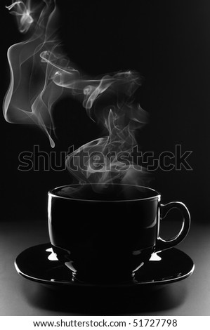 Black cup of coffee with steam on dark background.