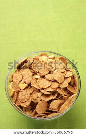 Glass bowl with breakfast cereal on green cloth with copy space.