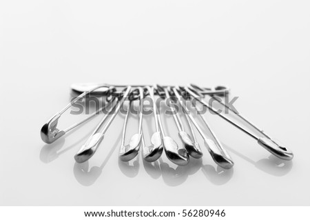 Bunch of safety pins on light background.