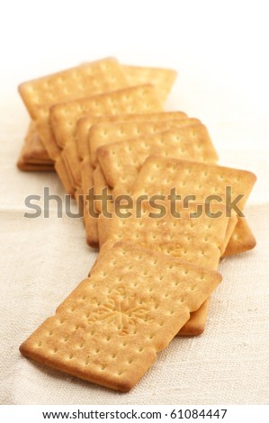 Heap of square crackers on beige cloth.