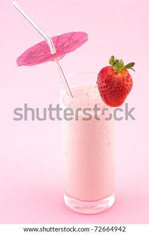 Strawberry protein cocktail with straw and decoration on pink background.