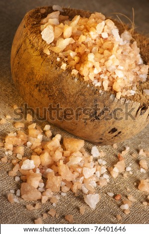 Bath salt in coconut shell and spilled on burlap.
