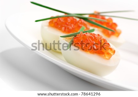 Canapes with egg, salmon caviar and onion.