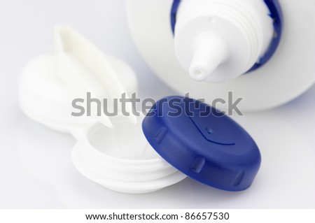 Contact lens container, tweezers and bottle of solution close-up.