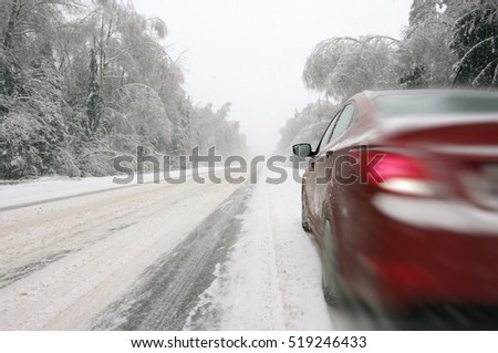 Moving car on snowy winter road among frozen forest after sleet. Cold weather, snowstorm, bad visibility, slippery road. Moscow area.